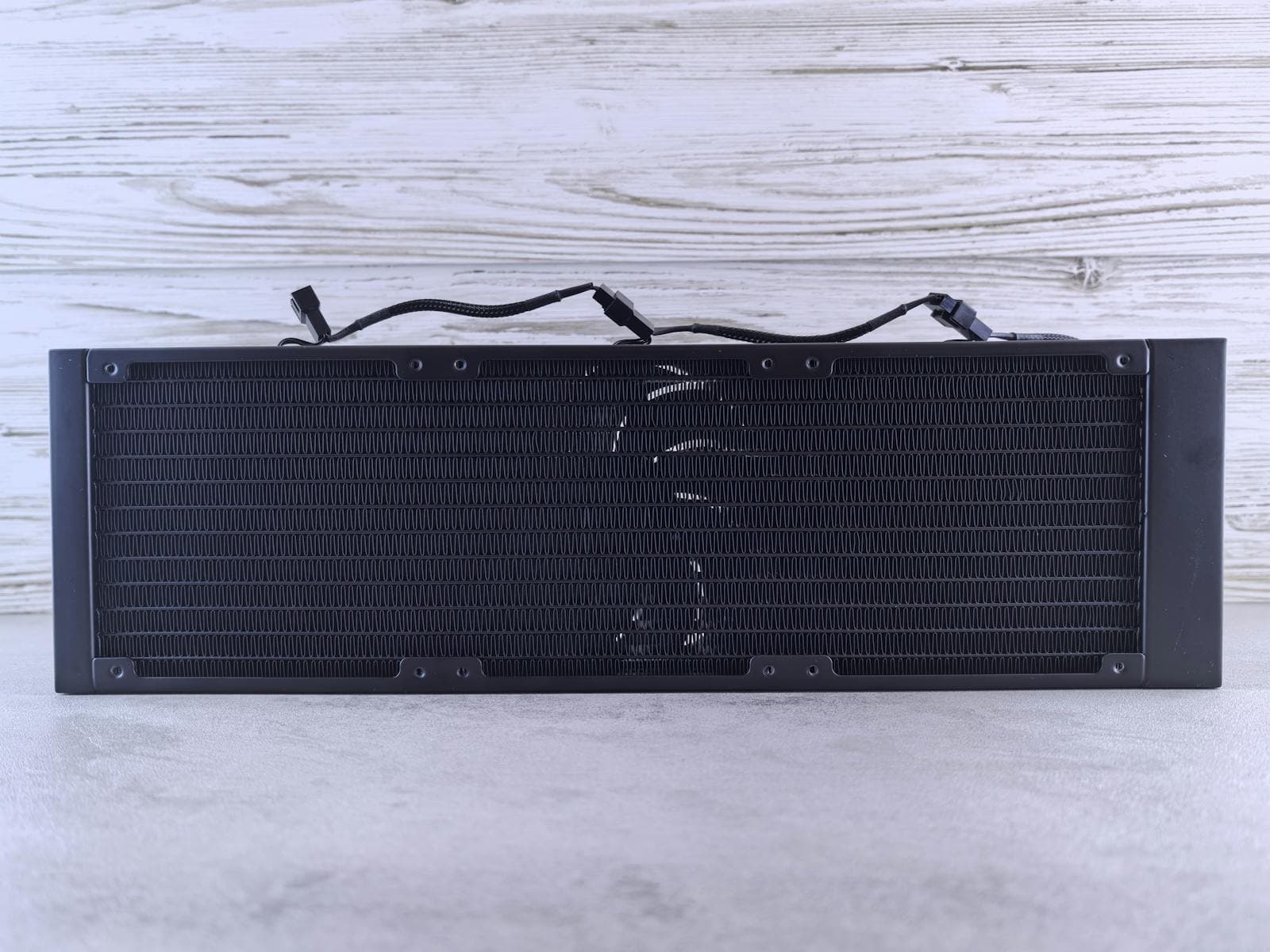 A black AIO liquid cooler radiator with fin structure visible — all-in-one liquid coolers use a radiator mounted to the case for heat dissipation, with a pump and waterblock on the CPU