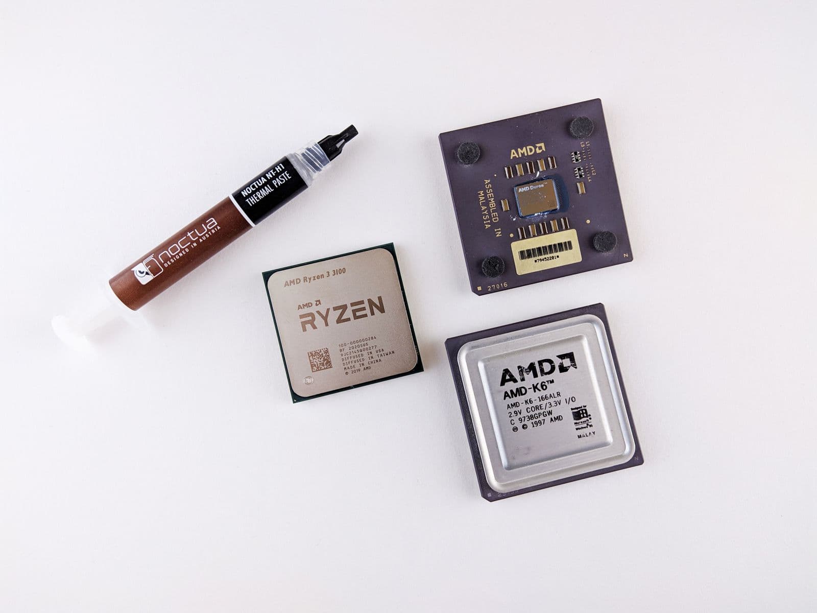Overhead view of AMD CPUs next to a tube of thermal paste