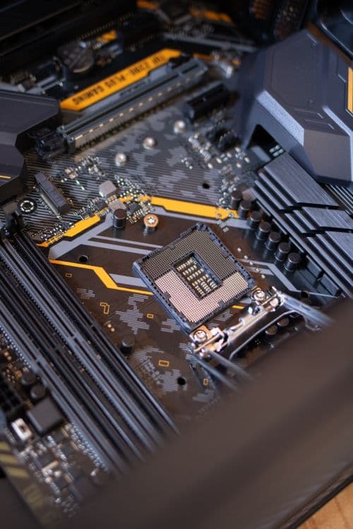 PC components on a desk including a motherboard and RAM sticks, representing the hardware decisions for a modded Minecraft build