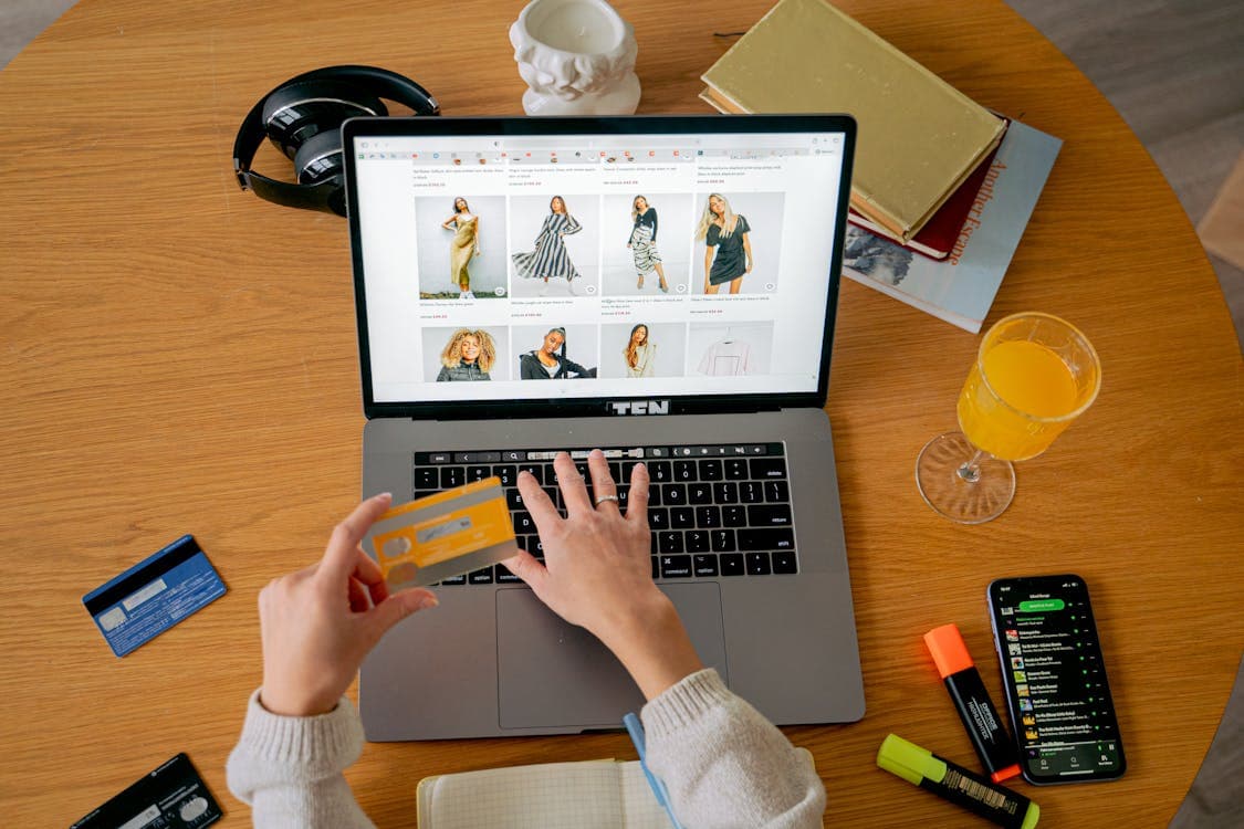 Person browsing an online marketplace on a laptop with credit card in hand — eBay's Money Back Guarantee makes it the safest place to buy used PC parts