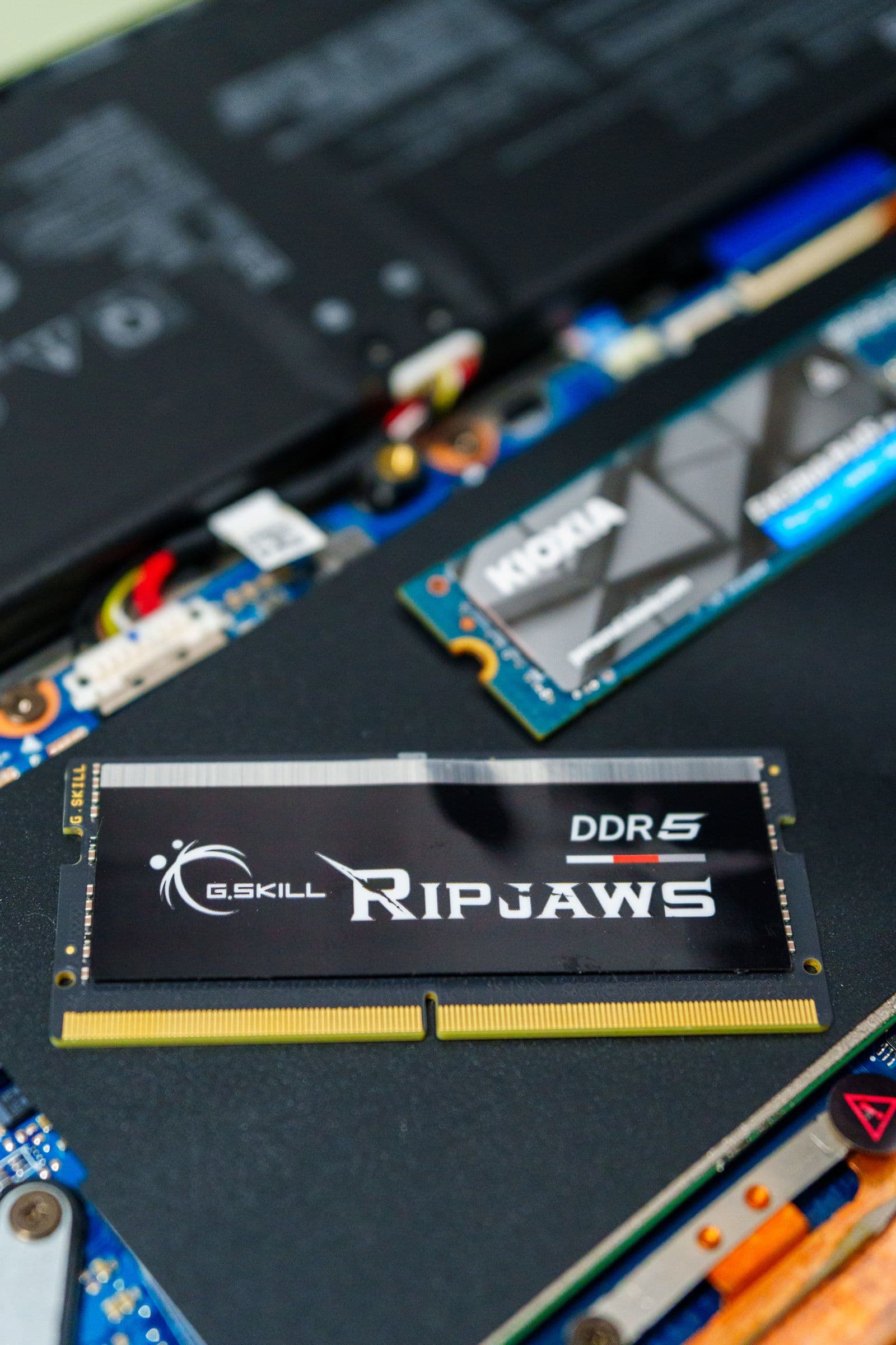 G.SKILL Ripjaws DDR5 RAM stick seated on a gaming motherboard, showing the chip layout and PCB detail
