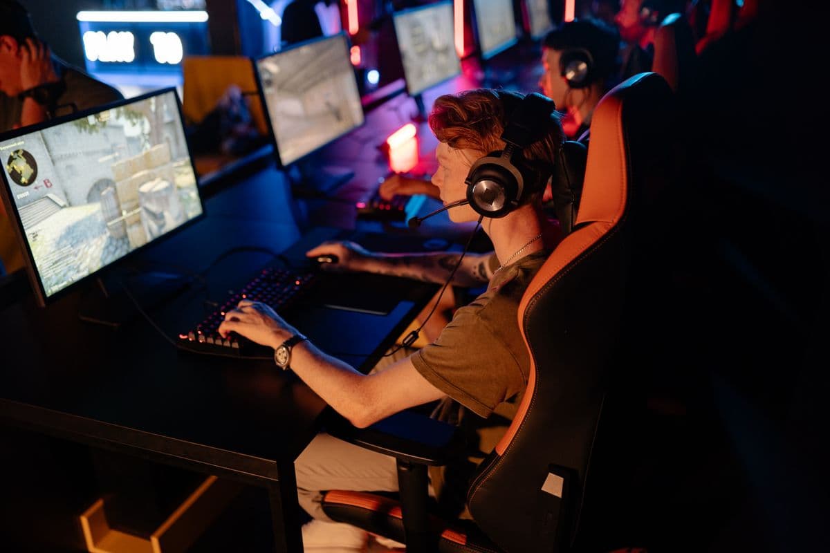 A group of gamers focused on competitive play in a dimly lit esports arena, showing the kind of performance a well-matched Fortnite PC build enables