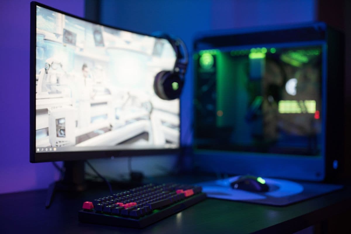 A high-tech gaming setup with curved monitor and RGB keyboard, representative of the kind of PC build that runs Fortnite at high frame rates