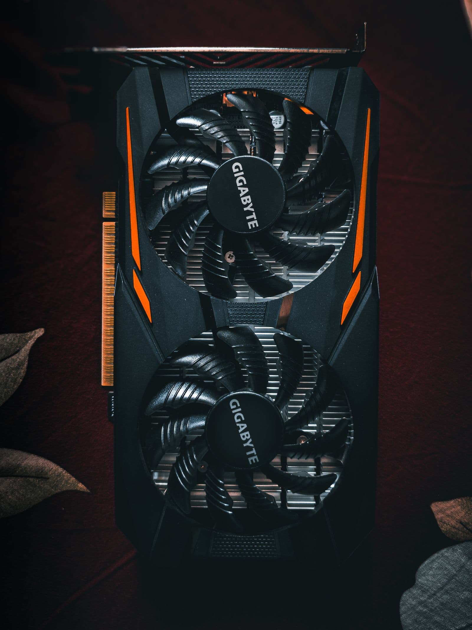 Close-up of a black and orange graphics card with cooling fans showing the RTX 5060 Ti tier of GPU that delivers genuine 1440p capability at the $400 price point in 2026