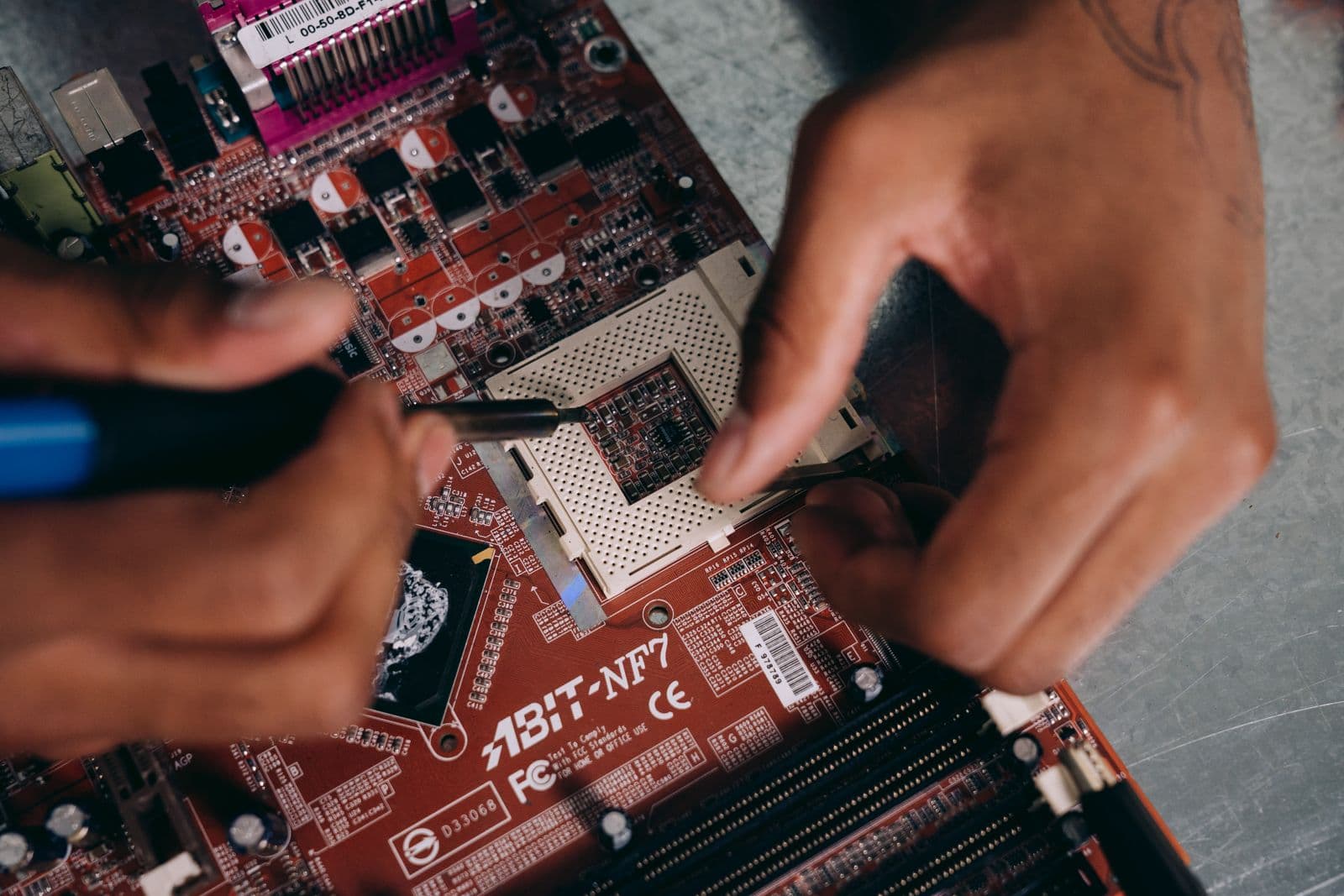Hands carefully working on a motherboard during CPU installation