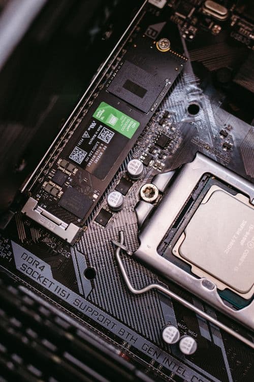 An M.2 SSD mounted on a motherboard next to the CPU socket, showing how the drive screws flat onto the board