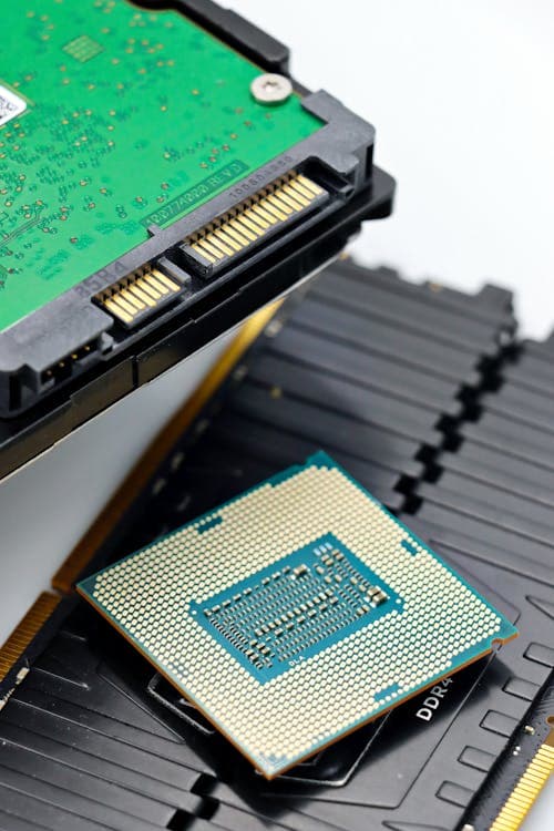 CPU, RAM sticks, and a storage drive laid out — these three components work together on the motherboard and should be selected as a compatible set